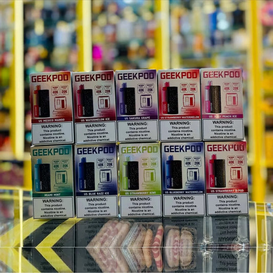 Stack of GeekPod vape device boxes with colorful packaging on a blurred background